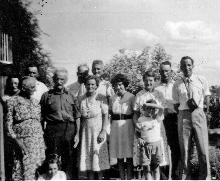 Family gathering near the front corner of the old house