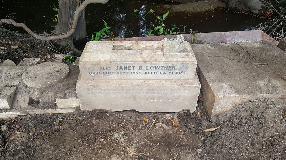 Image of Remnants of COLQUHOUN gravestone buried in flood mitigation wall at Albany Creek. 